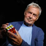 White man holding Rubiks cube