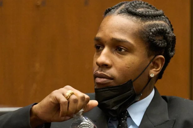 Black man with cornrows wearing black suite in court