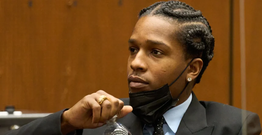 Black man with cornrows wearing black suite in court