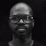 Black man with black glasses and a black background