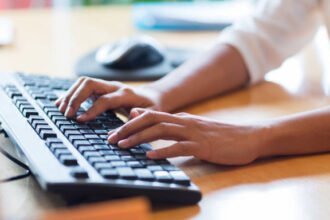 White person typing on a keyboard