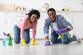 A woman and a man cleaning the floor in the kitchen